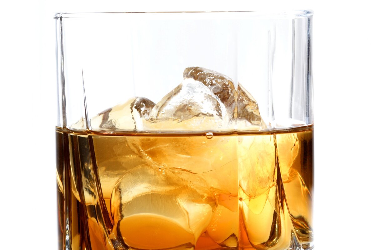 Whisky na dużych kostkach lodu w szklance, przed dolaniem wody gazowanej